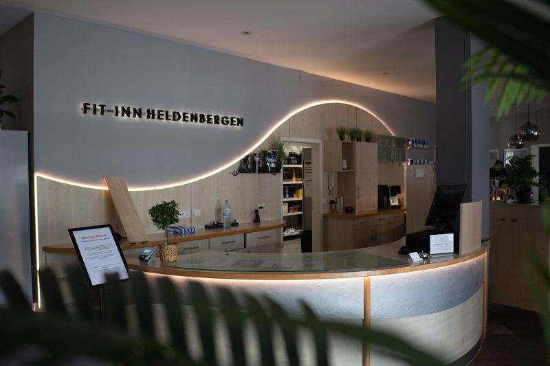 Empfangsbereich mit beleuchteter Rezeptionstheke im Fit-Inn Heldenbergen Nidderau