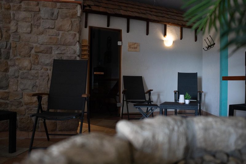 Sanarium mit Ruhesesseln und Natursteinwand im Wellnessbereich des Fit-Inn Heldenbergen