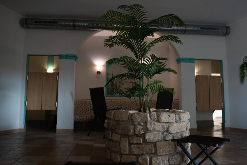 Ruhebereich der Sauna mit Brunnen und Umkleidekabinen im Fit-Inn Heldenbergen